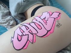 a woman with pink graffiti on her thigh