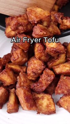 fried tofu on a white plate with a wooden spoon