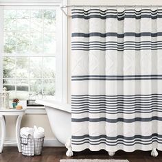 a bathroom with a bathtub, shower curtain and rug in front of the window