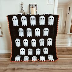 a crocheted blanket with pacman faces on it, sitting on top of a hard wood floor