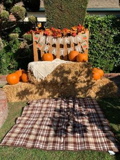 pumpkins and hay bales are arranged on the lawn