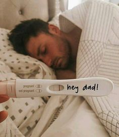 a man is sleeping in bed with an iv tube attached to his arm that says hey dad