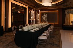 a long table set up with white flowers and candles