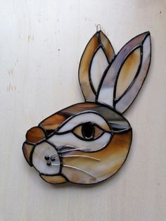 a stained glass rabbit head hanging on a wall