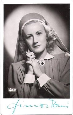 an old black and white photo of a woman wearing a nun outfit with a flower in her hair