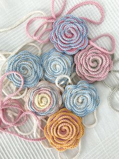 several crocheted flowers on a white table cloth