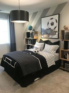 a bedroom decorated in black and white with soccer themed decor on the wall above the bed