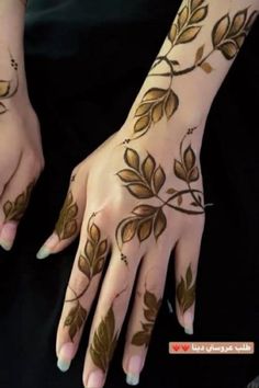 a woman's hands with hennap and leaves painted on her hand,