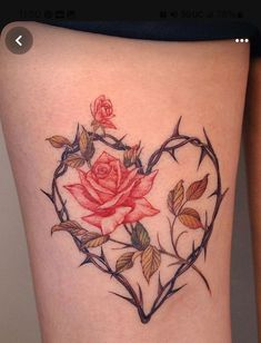 a heart shaped rose tattoo on the side of a woman's thigh with vines and leaves surrounding it