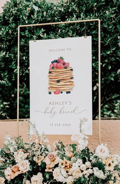 a sign that says welcome to ashley's bakery and is surrounded by flowers