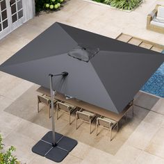 an open umbrella on top of a table next to a pool