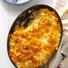 a casserole dish with cheese and onions in it on a white tablecloth