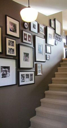 the stairs are lined with pictures and framed photographs