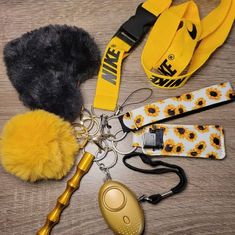 the contents of a purse laid out on a wooden table with yellow and black accessories