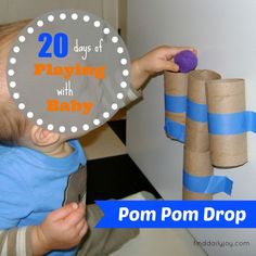 a baby is playing with some toilet paper rolls and holding a purple ball in it's mouth