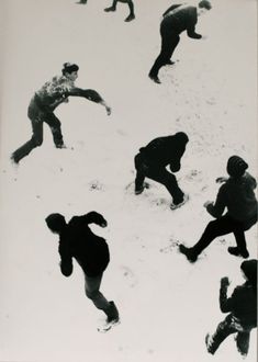 black and white photograph of people playing in the snow