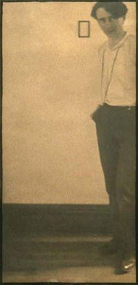 an old photo of a man standing in front of a wall with a clock on it