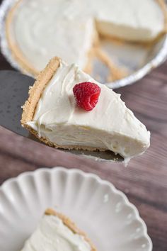 a piece of pie on a white plate with a raspberry in the middle