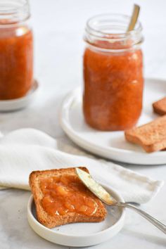 two plates with peanut butter and toast on them, one has a spoon in it