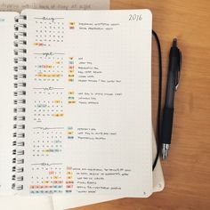 a notebook with a calendar and pen on top of it