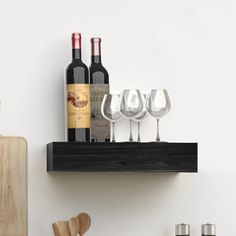 there are wine glasses and bottles on the shelf