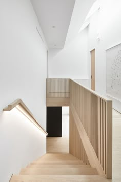 an empty staircase with wooden handrails and white walls