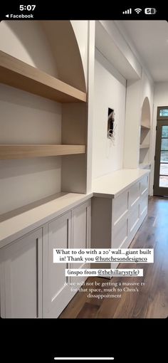 an image of a kitchen with white cabinets and wood flooring on the phone screen