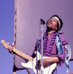 a man with a guitar in front of a microphone