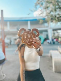 a woman holding up a pretzel in front of her face