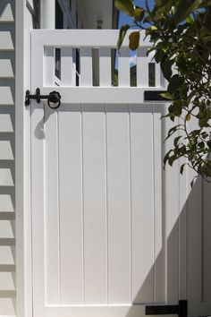 a white gate with a black handle on it