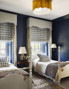 a bedroom with blue walls and white bedding, two lamps on either side of the beds