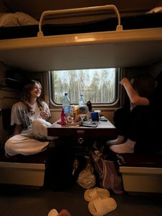 two people sitting at a table on a train