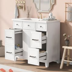 a bathroom vanity with two drawers and a mirror on the wall next to a stool