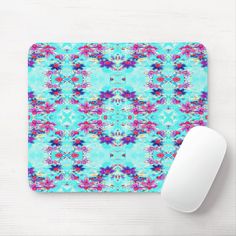 a blue and pink mouse pad sitting on top of a white desk next to a computer mouse