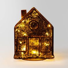 a lighted house shaped like a candle holder