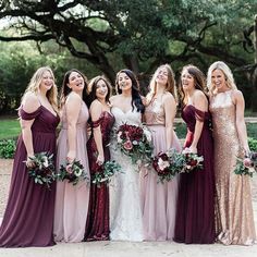 a group of women standing next to each other wearing dresses and holding bouquets in their hands