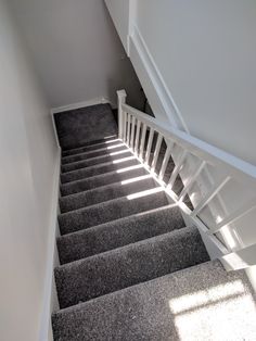 stairs leading up to the second floor in a house with white railings and carpet