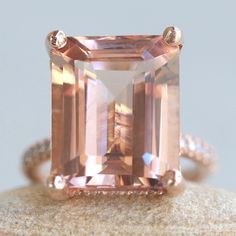 This Diamond Prong Morganite Ring is part of our Olivia Collection, which is characterized by a gorgeous, genuine gemstone with Golden Hearts under it. Diamonds stud the hidden halo and sparkle down the half eternity shank.  Custom initials at the back of the shank are available on all rings upon request!  Center Stone: Genuine AAA Peachy Pink Morganite, Emerald Cut, averaging 15x12mm and 10 carats. Side Stones: 68 Diamonds – you choose Lab Grown or Organic – averaging F-G, VS2-SI1 and 0.46 cara Classic Morganite Jewelry With Prong Setting, Radiant Cut Morganite Wedding Jewelry, Classic Morganite Gemstone Rings, Rose Gold Octagon Ring With Prong Setting, Rose Gold Octagon Jewelry With Prong Setting, Dazzling Morganite Rings For Anniversary, Classic Morganite Jewelry With Accent Stones, Morganite Radiant Cut Jewelry For Anniversary, Morganite Center Stone Jewelry For Anniversary