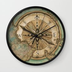 a wall clock with a compass on it's face and the word w e