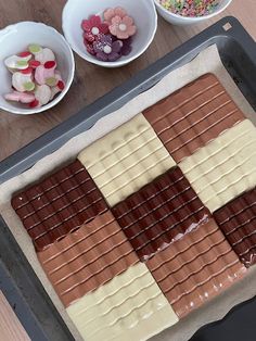 there are many different types of chocolates on the tray together, including candy and marshmallows