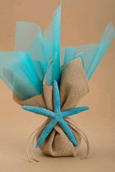 a blue starfish decoration in a burlocked bag on a beige background