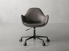 an office chair with casteors and wheels on a gray floor in front of a white wall