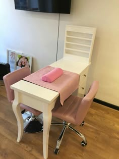 a desk and chair with a pink pillow on it