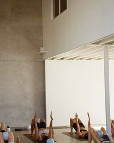 there are many people doing yoga on the floor with their hands up in the air