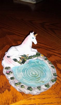 a ceramic unicorn sitting on top of a wooden table