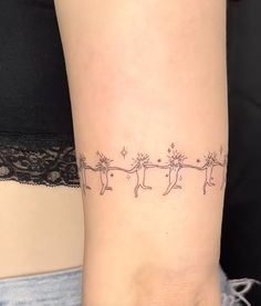 a woman's arm with a line drawing of cats and stars on the wrist