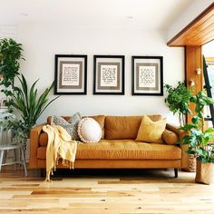 a living room with three framed pictures on the wall and two couches in front of them