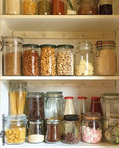 an organized pantry filled with lots of different types of nuts and other food items in glass jars