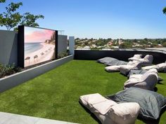 an outdoor movie on the roof of a building with lounge chairs and bean bag pillows