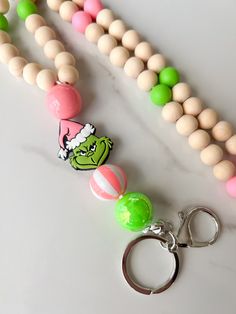 an assortment of beads and keychains on a marble surface with a grin face charm